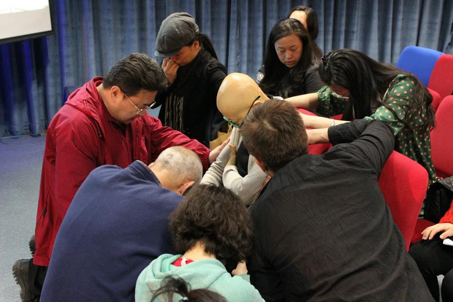 新玮姊妹见证会现场，身体疼痛，大家围在一起为她祷告。（图：基督时报/徐敬谦）