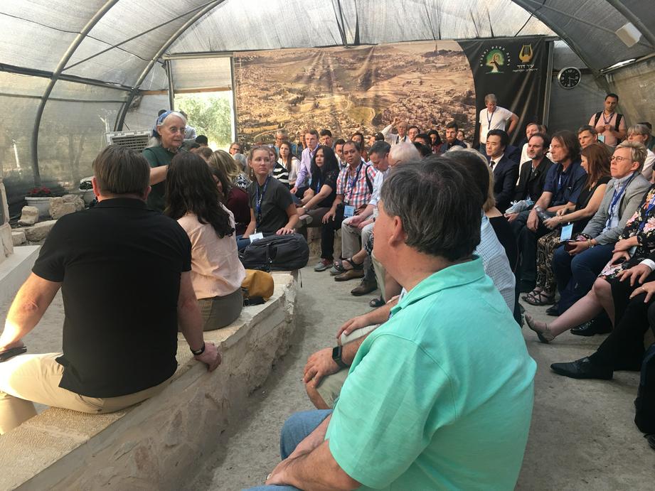 考古学家向参会者讲解古代文物挖掘