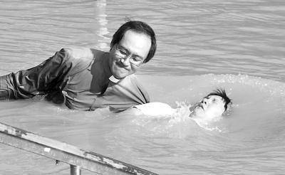 基督徒游客在耶胡达的约旦河水中接受洗礼。(图:光明日报)