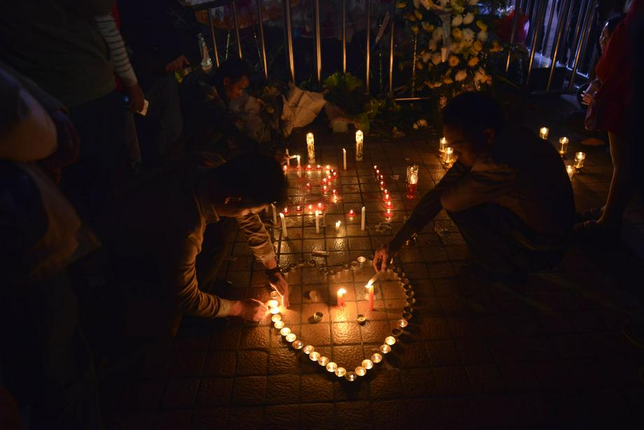 (图片:民众在昆明火车站点蜡烛祈祷)